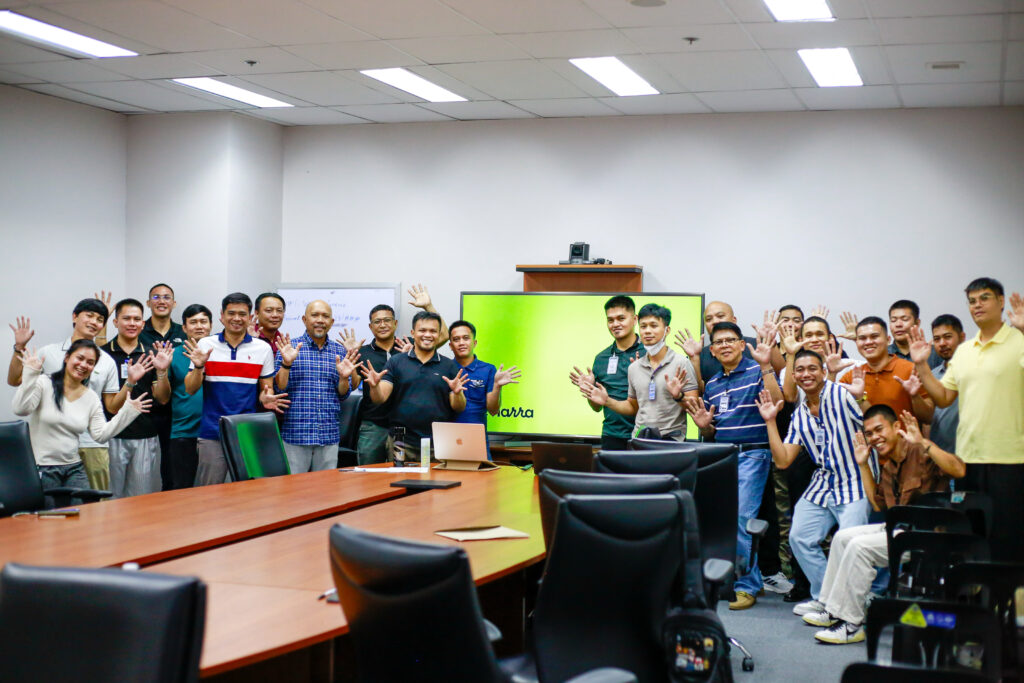 Seafarers happily posing infront of a Narra Health presentation. Mental Health support for Seafarers and their families.
